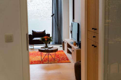 a living room with a television and a chair and a table at Cheval Blanc - Holiday Rental in Aubel