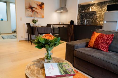 uma sala de estar com um vaso de flores sobre uma mesa em Cheval Blanc - Holiday Rental em Aubel