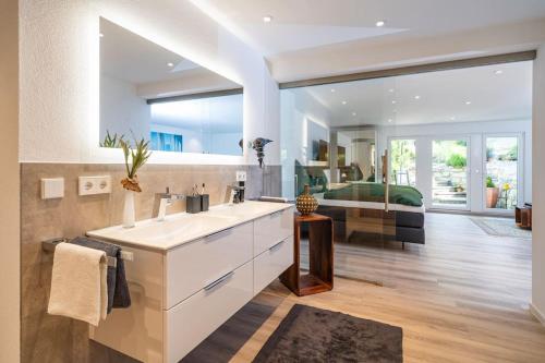 a bathroom with a sink and a large mirror at Haus Anni in Immenstaad am Bodensee