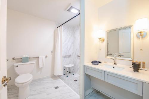 a white bathroom with a toilet and a sink at Kent Island Resort in Stevensville