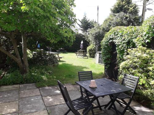 einen Picknicktisch und zwei Stühle in einem Garten in der Unterkunft Thorverton Arms in Exeter