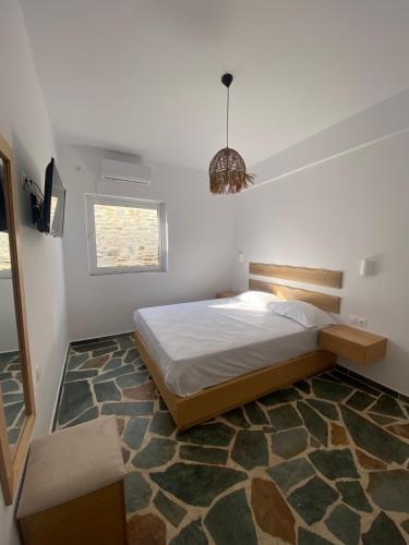 a bedroom with a large bed and a chandelier at Villa Acta in Kithnos