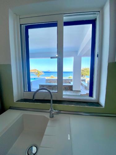 a kitchen sink with a window with a view of the ocean at Villa Acta in Kithnos