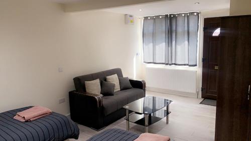 a living room with a couch and a coffee table at Mon Repos Heathrow - Hatton Cross Station 2 Stops from Heathrow Underground Free WiFi Free Parking Free Refreshments in New Bedfont