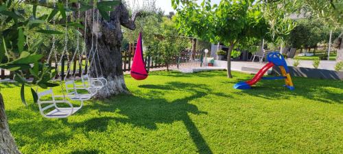 park z huśtawką i drzewem w obiekcie Garlis Apartments w mieście Psakoudia