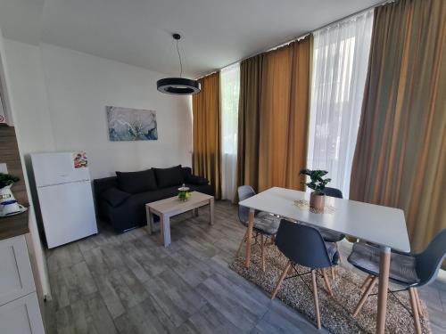 sala de estar con sofá, mesa y sillas en Бутикови апартаменти Емона, en Ravda
