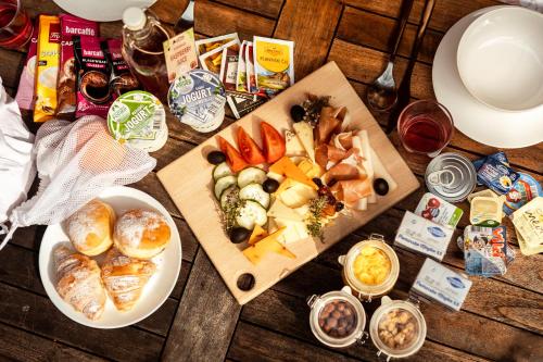 a wooden table topped with plates of food and snacks at Glamping Mountain Fairy Tale in Bistrica pri Tržiču