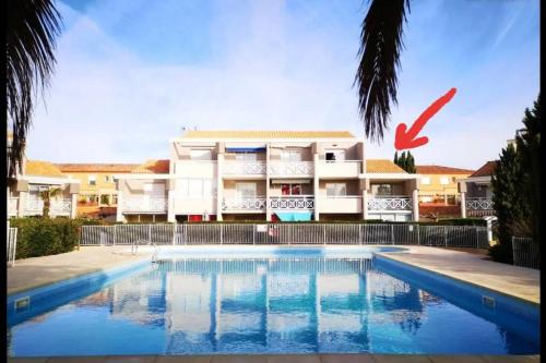 un immeuble avec une piscine devant un immeuble dans l'établissement Valras Plage - Appartement - 4 pers - piscine, à Valras-Plage