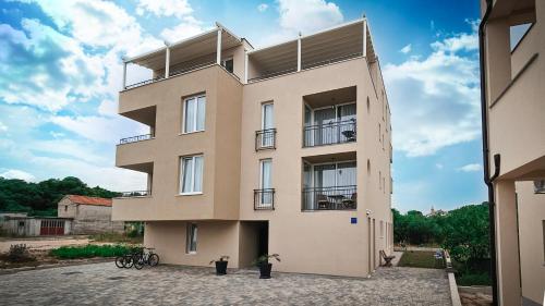 a large beige building with balconies on it at Casa Mili Jezera in Jezera