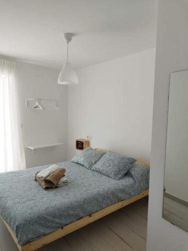 een witte slaapkamer met een bed met blauwe lakens bij Un Lugar Llamado Descanso en Monfrague in Torrejón el Rubio