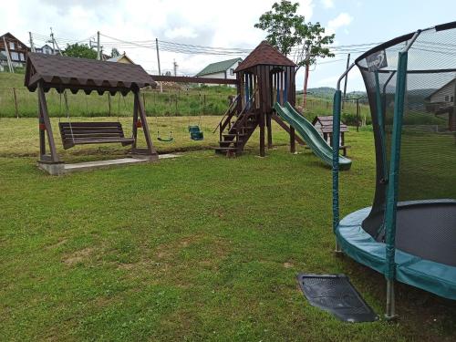 un parque infantil con tobogán y columpio en Guest House Mountain en Bukovel