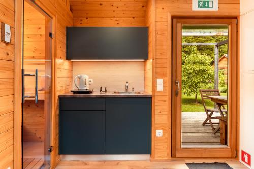 a kitchen with a sink and a door to a patio at Glamping Mountain Fairy Tale in Bistrica pri Tržiču