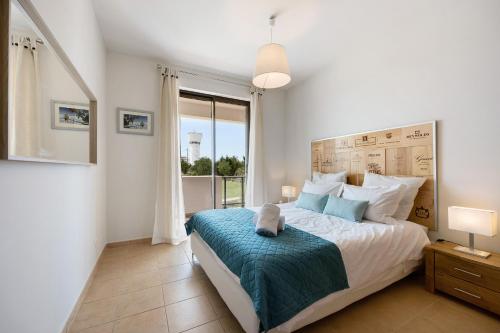 um quarto com uma cama e uma grande janela em Devvine Beach and Golf em Alvor