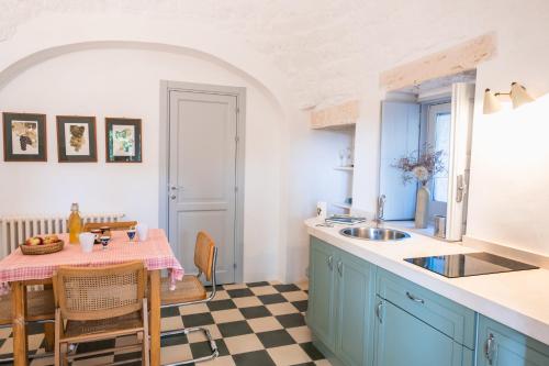 una cocina con armarios azules y una mesa con fregadero en I Giardini di Pomona, en Cisternino