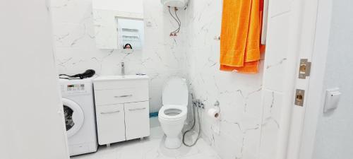 a bathroom with a toilet and a washing machine at ЖК PRESIDENT в 5 мин от моря in Aktau