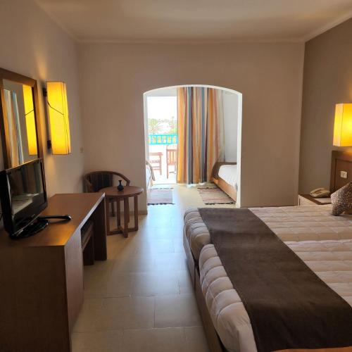 a hotel room with a bed and a television at Golf Beach & Thalasso- Families and Couples in Triffa
