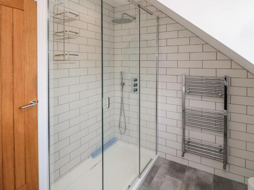 a shower with glass doors in a bathroom at Willow Cottage in Morpeth