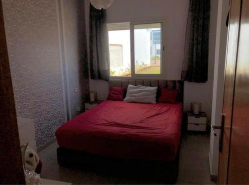- une chambre avec un lit rouge et une fenêtre dans l'établissement Les terrasses, à Mohammedia
