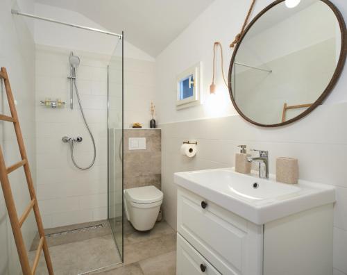 ein Badezimmer mit einem WC, einem Waschbecken und einem Spiegel in der Unterkunft House Gajarda in Rab