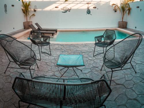 a group of chairs sitting around a swimming pool at Casa Lavandas in Mérida