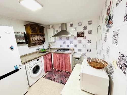 eine Küche mit einer Waschmaschine, einer Waschmaschine und einem Trockner in der Unterkunft Cozy Town House With Terrace and Free Wifi in Ronda