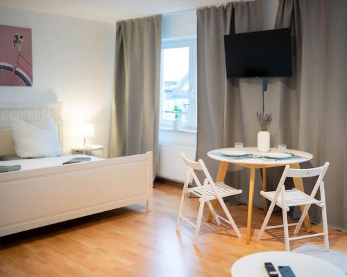 - une chambre avec un lit, une table et des chaises dans l'établissement Centre Apartment, à Leipzig