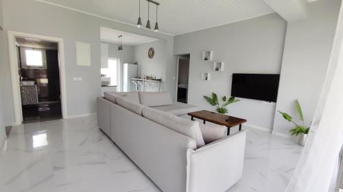 a white living room with a couch and a table at Villetta del mare corfu in Perivolion
