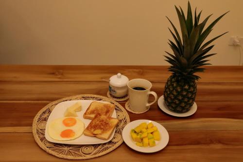 a table with two plates of breakfast food and a pineapple at Hostal Casa Torres Centro Historico - Adults Only in Cartagena de Indias