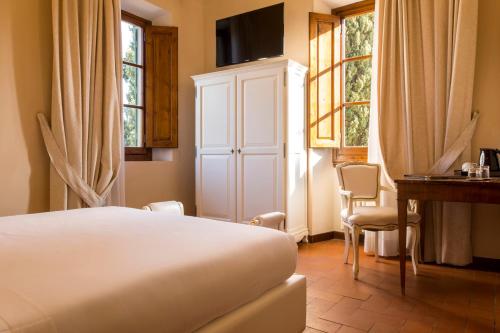 a bedroom with a bed and a desk and windows at Art Hotel Villa Agape - Place of Charme in Florence