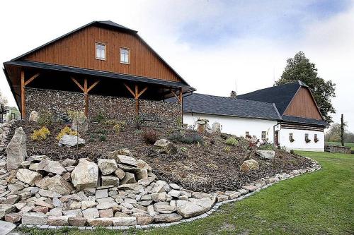 a house with a stone garden in front of a building at Penzion pod Březinkou in Polička
