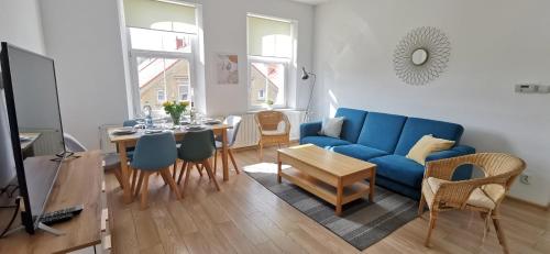 uma sala de estar com um sofá azul e uma mesa em Słoneczny apartament blisko jeziora i gór em Bielawa