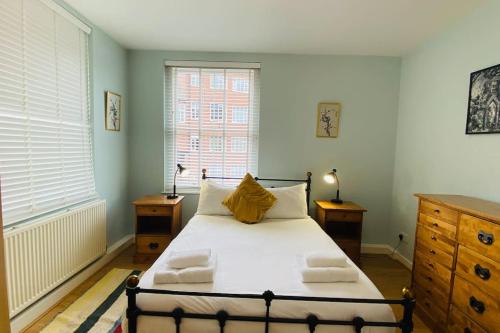 a bedroom with a bed with white sheets and a window at Historic Kelham House with FREE on-site Parking in Sheffield