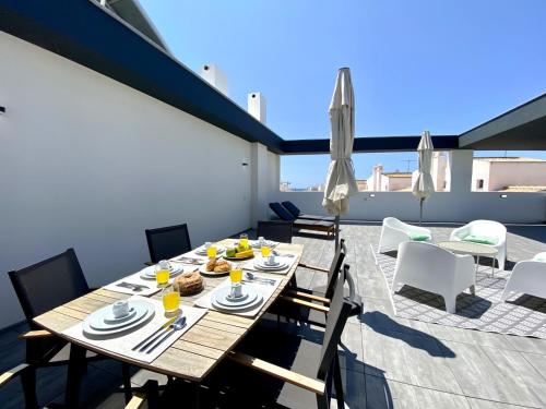 a dining table on the roof of a house at Tavira Grand Balcony With Pool by Homing in Tavira