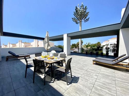 a patio with a table and chairs on a roof at Tavira Grand Balcony With Pool by Homing in Tavira