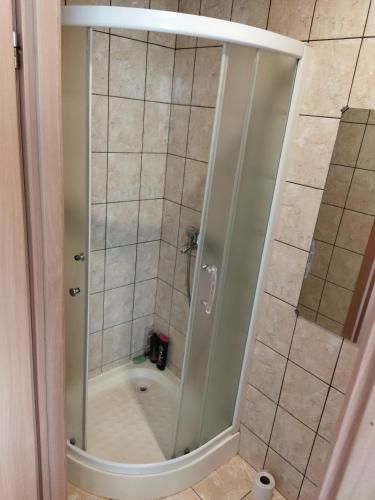 a shower with a glass door in a bathroom at Itaja apartment 50 in Šiauliai
