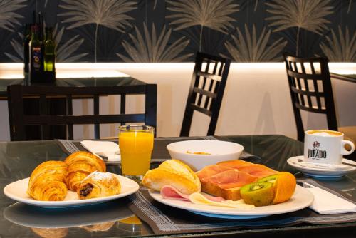 una mesa con dos platos de bollería y zumo de naranja en Hotel Eden Mar, en Guardamar del Segura