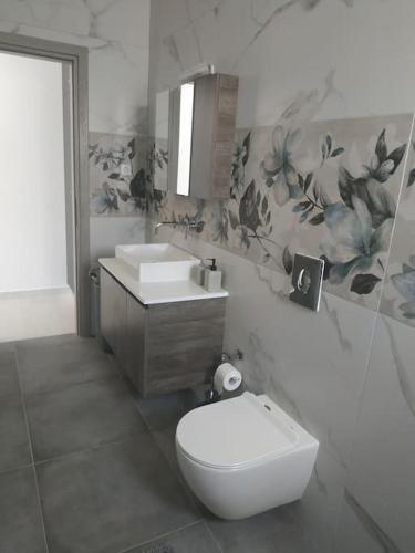 a bathroom with a toilet and a sink at Restaurant Maria Suites SunRise in Faliraki