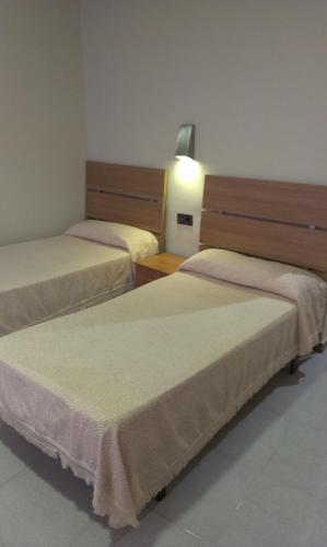 a hotel room with two beds and a lamp at Hostal Bisbal ONLY ADULTS NO AC in Valencia