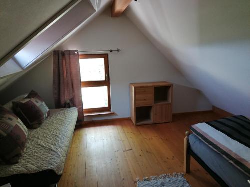 a attic room with a couch and a window at Spehnerhof in Vogt