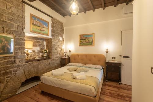 a bedroom with a bed and a stone wall at Boutique Ponte Vecchio in Florence