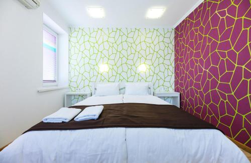 a bedroom with a large bed and a colorful wall at Guest house "Golden Gate 911 " in Kyiv