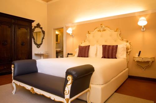 a bedroom with a large white bed and a chair at Art Hotel Villa Agape - Place of Charme in Florence