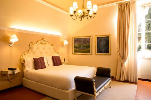 a bedroom with a large white bed and a chandelier at Art Hotel Villa Agape - Place of Charme in Florence