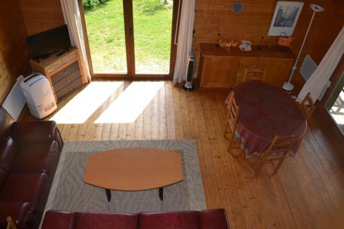 an overhead view of a living room with a table and chairs at Chalet au bord d'un étang, près d'une ferme pédagogique in Château-Voué