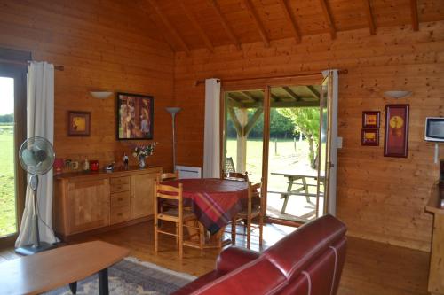 a living room with a couch and a table in a cabin at Chalet au bord d'un étang, près d'une ferme pédagogique in Château-Voué