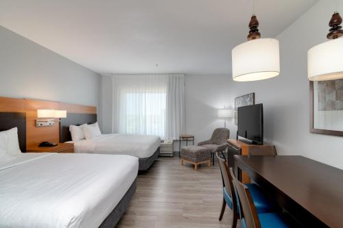 a hotel room with two beds and a television at TownePlace Suites by Marriott Dallas McKinney in McKinney