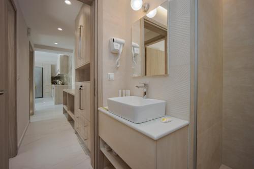 a bathroom with a white sink and a mirror at Vert House near The Beach in Agia Pelagia