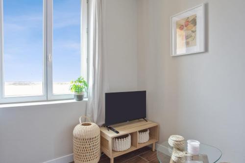 een woonkamer met een tv en een raam bij Very nice flat with AC two steps away from the sea - Bandol - Welkeys in Bandol