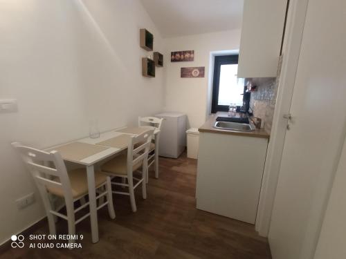 a kitchen with a table and chairs and a sink at Fontanarossa Airport Sleep and Travel in Catania