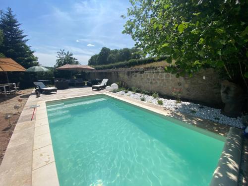 a swimming pool in the backyard of a house at Chambre d'hôtes La Chouette in Saint-Martin-du-Puy